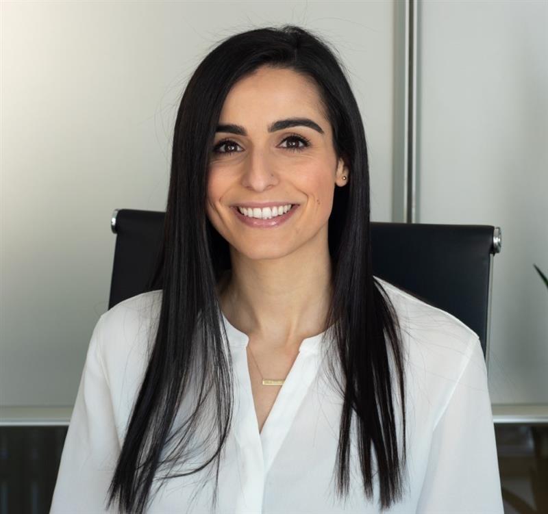 Headshot of Cortney Hanna-Benson, smiling, shown from the chest up and wearing a white shirt.