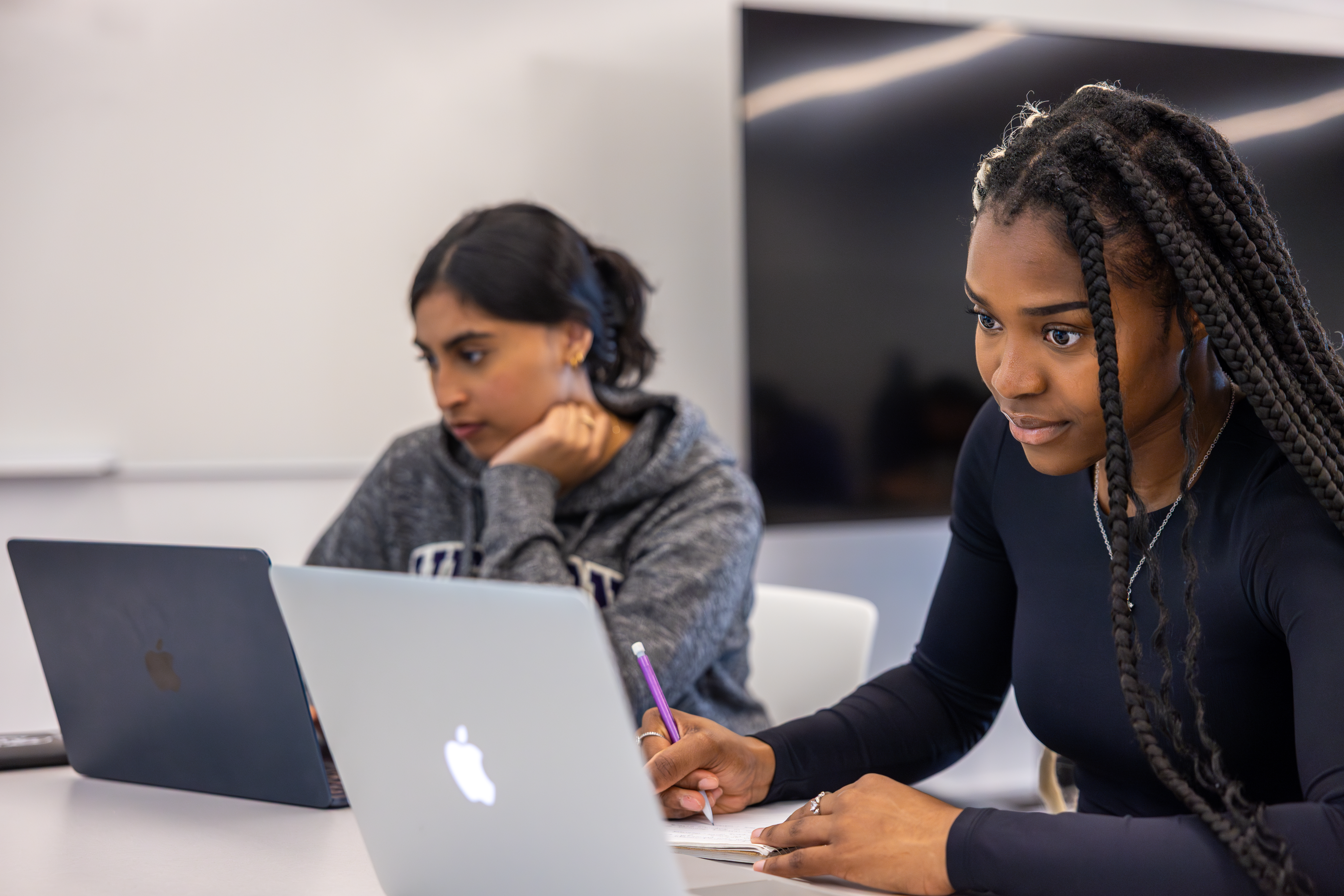 photo of two students working on laptops